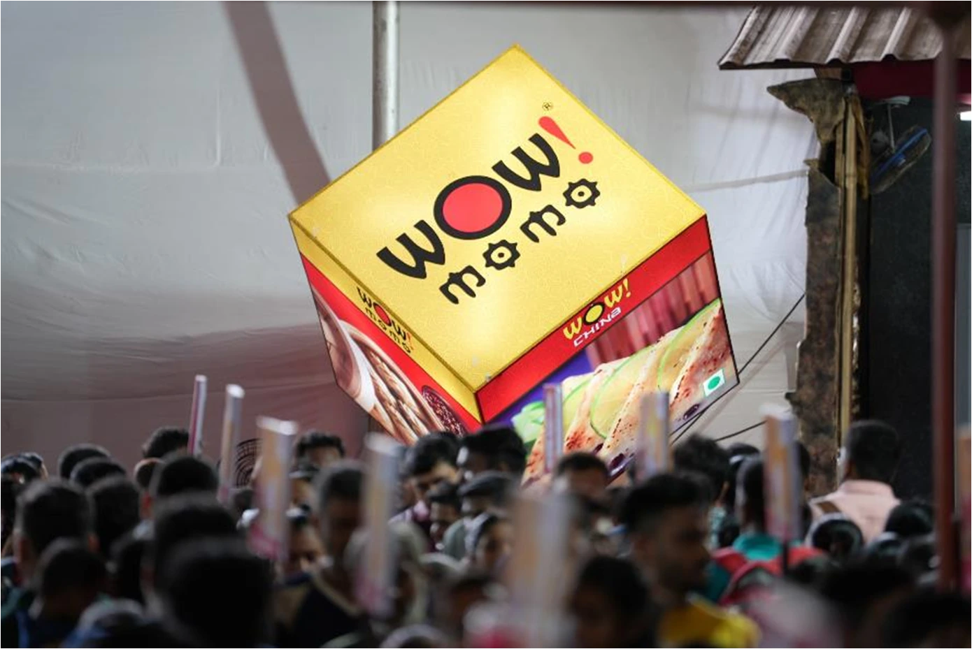 Wow Momo food stall branding at a crowded Indian religious event by Fateh Rural Limited